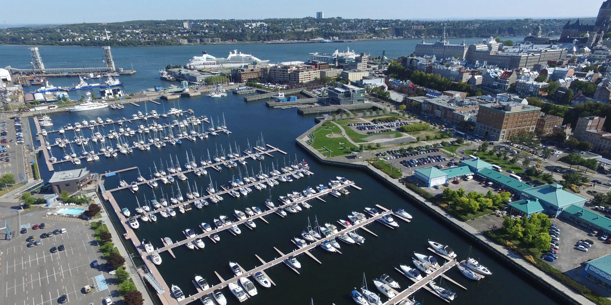 Aerial view of the marina with boats and Québec city in the background.